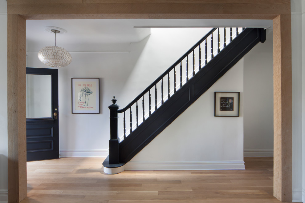 This is an example of a transitional wood straight staircase in New York with wood risers and wood railing.