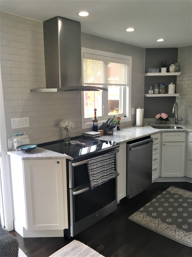 Small transitional u-shaped dark wood floor and brown floor eat-in kitchen photo in Boston with an undermount sink, shaker cabinets, white cabinets, quartz countertops, gray backsplash, subway tile backsplash, stainless steel appliances and gray countertops
