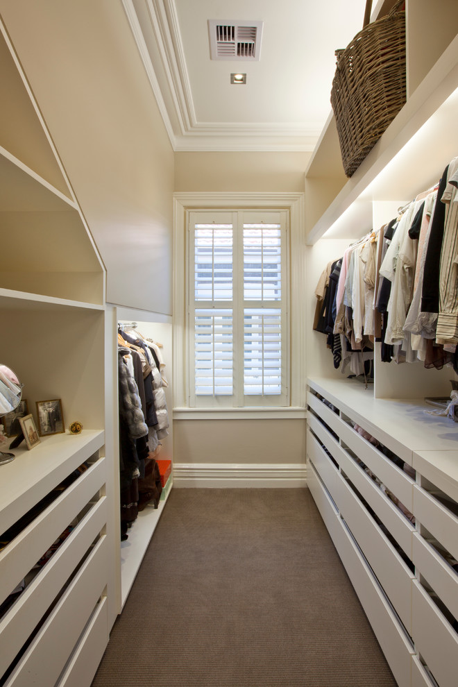 Inspiration for a large transitional gender-neutral walk-in wardrobe in Sydney with flat-panel cabinets, white cabinets and carpet.