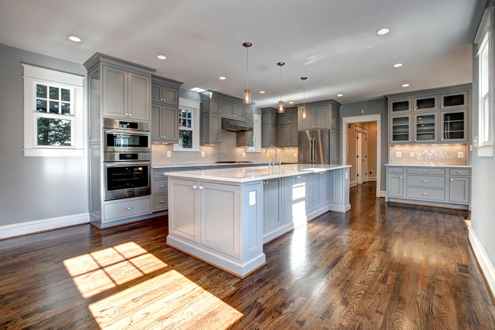 Inspiration for a mid-sized craftsman l-shaped medium tone wood floor open concept kitchen remodel in DC Metro with a single-bowl sink, beaded inset cabinets, gray cabinets, quartzite countertops, white backsplash, mosaic tile backsplash, white appliances and an island
