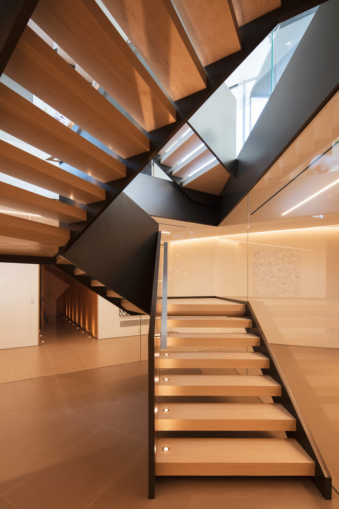 Expansive modern wood floating staircase in Los Angeles with open risers and metal railing.