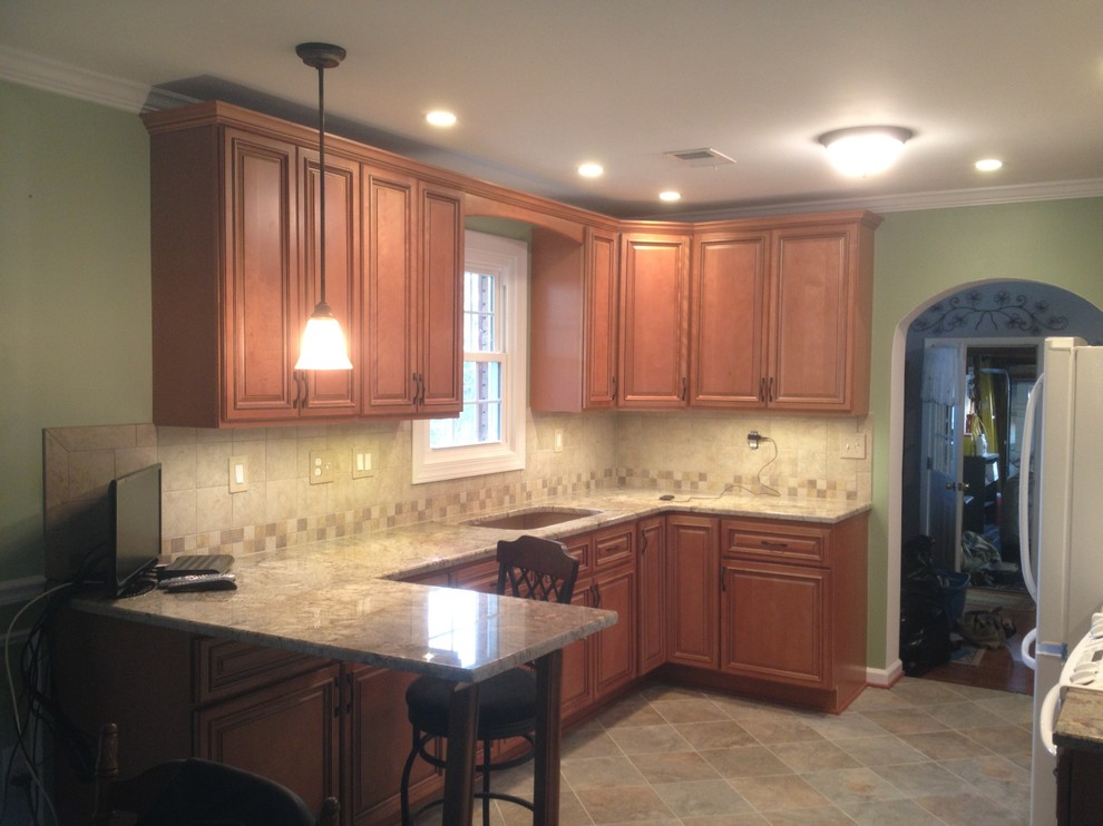 Example of a kitchen design in DC Metro with a single-bowl sink, beaded inset cabinets, medium tone wood cabinets, granite countertops, white appliances and a peninsula