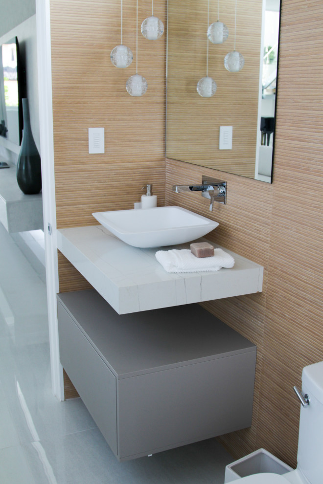 Photo of a small contemporary 3/4 bathroom in Miami with flat-panel cabinets, grey cabinets, a one-piece toilet, beige tile, ceramic tile, beige walls, ceramic floors, a vessel sink, engineered quartz benchtops, grey floor, white benchtops, a single vanity and a floating vanity.