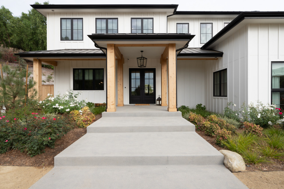 Inspiration for an expansive country two-storey white house exterior in Los Angeles with mixed siding and a black roof.
