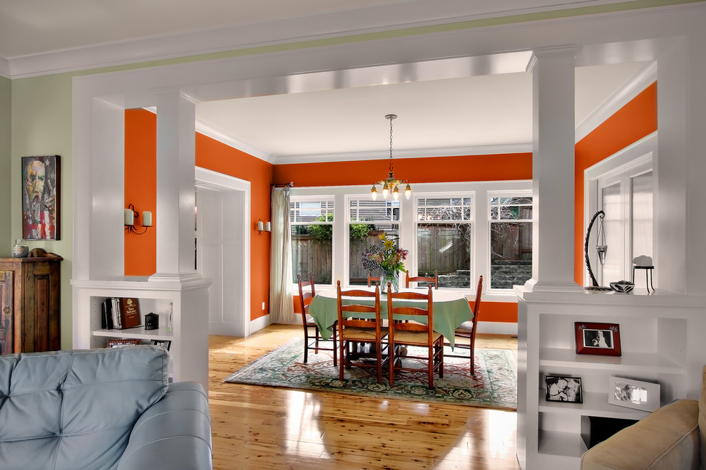 Design ideas for an arts and crafts dining room in Seattle with orange walls.