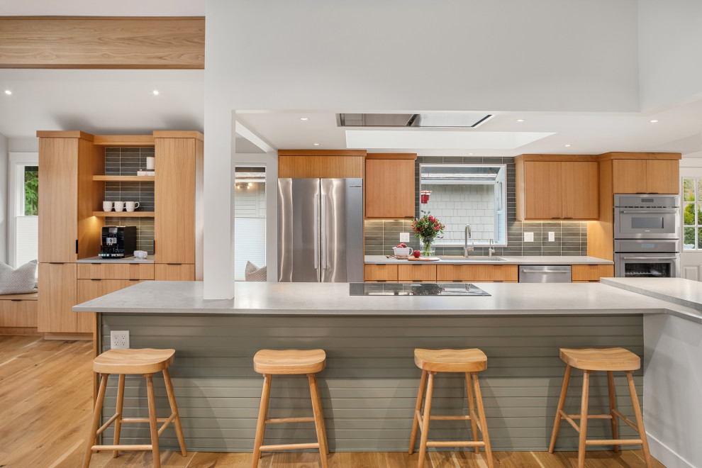 Inspiration for a mid-sized transitional light wood floor and exposed beam open concept kitchen remodel in Seattle with an undermount sink, flat-panel cabinets, light wood cabinets, quartz countertops, green backsplash, ceramic backsplash, stainless steel appliances, an island and gray countertops