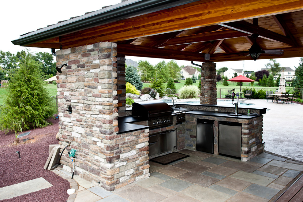 Inspiration for a backyard stone patio kitchen remodel in Philadelphia