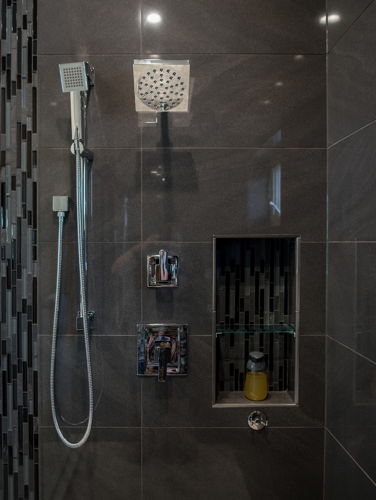 Photo of a large modern master bathroom in Denver with flat-panel cabinets, dark wood cabinets, a freestanding tub, a double shower, a one-piece toilet, black tile, mosaic tile, grey walls, porcelain floors, a vessel sink and engineered quartz benchtops.