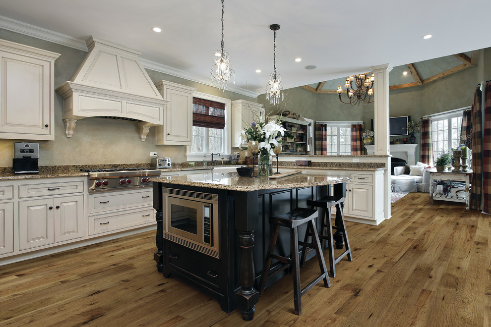 Inspiration for a large contemporary galley separate kitchen in Boise with a farmhouse sink, recessed-panel cabinets, white cabinets, granite benchtops, stainless steel appliances, medium hardwood floors and no island.