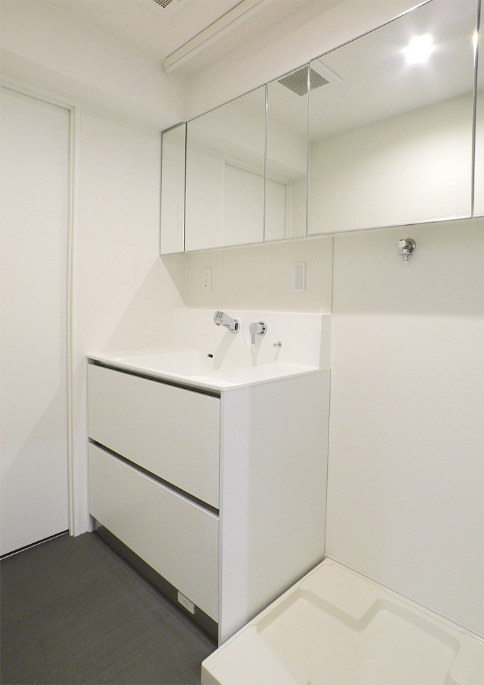Mid-sized midcentury laundry room in Yokohama with flat-panel cabinets, white cabinets, solid surface benchtops, linoleum floors, grey floor, wallpaper and wallpaper.