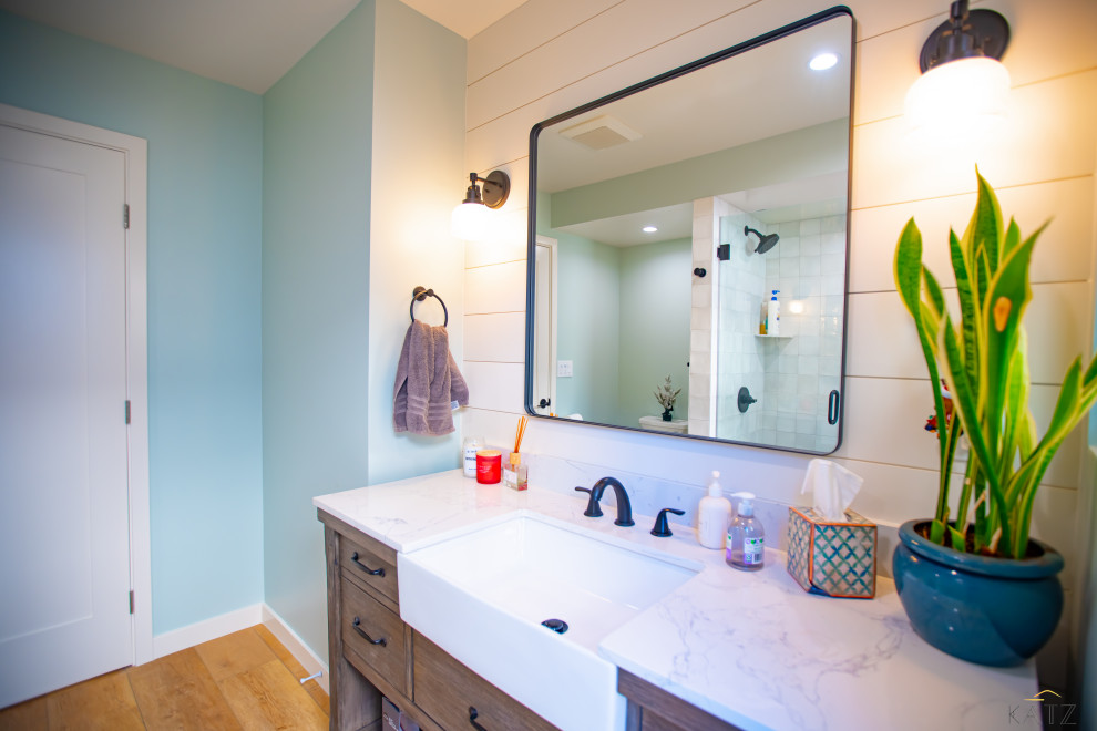 Réalisation d'une salle de bain en bois brun de taille moyenne avec WC à poser, parquet clair, un plan de toilette en marbre, un sol orange, un plan de toilette blanc, meuble simple vasque et meuble-lavabo sur pied.