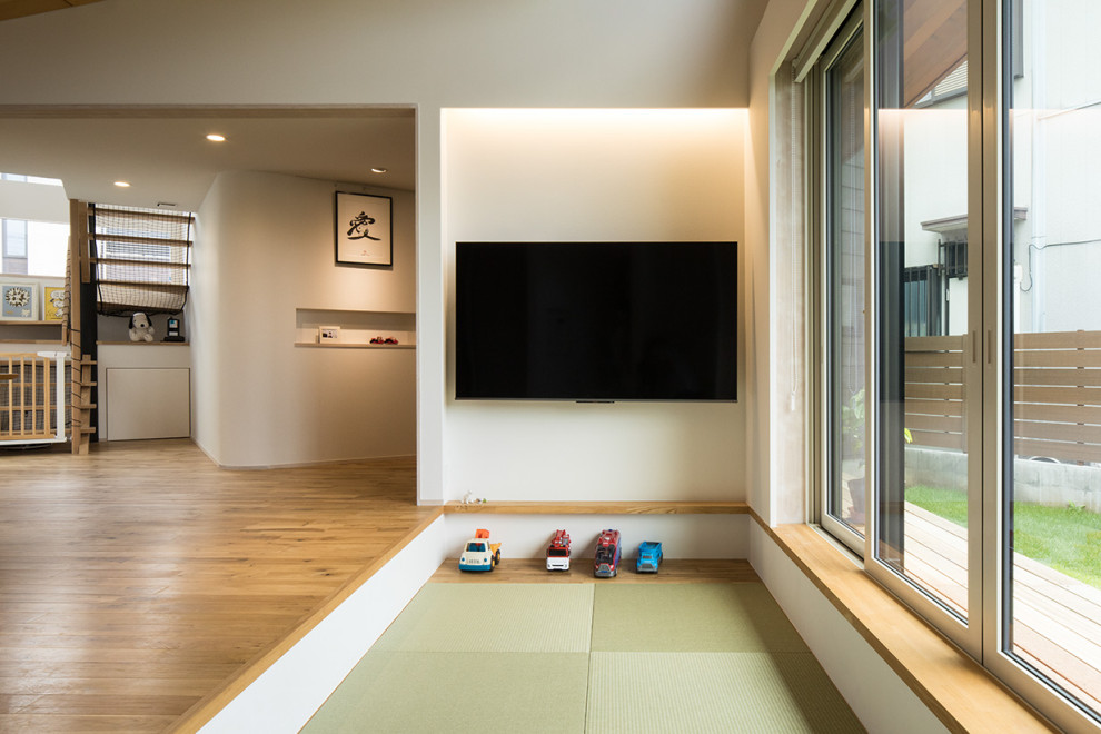 Réalisation d'une salle de séjour vintage avec un mur blanc, un sol de tatami et un téléviseur fixé au mur.