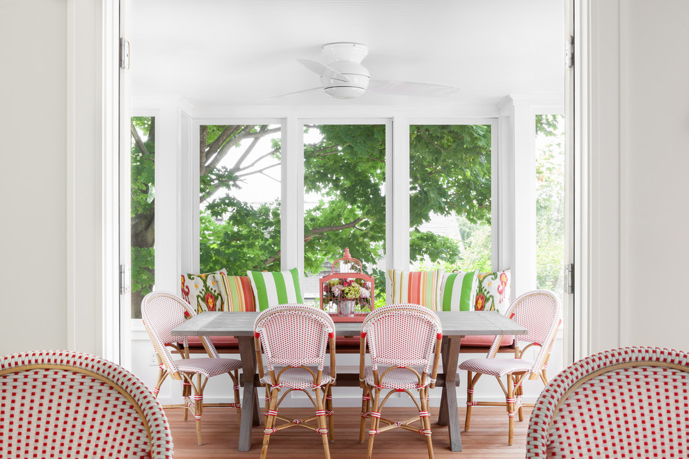 This is an example of a beach style separate dining room in Boston with medium hardwood floors and white walls.