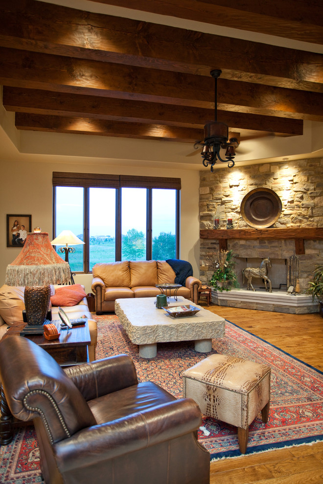 This is an example of a large traditional open concept family room in Chicago with beige walls, medium hardwood floors, a standard fireplace, a stone fireplace surround and a wall-mounted tv.