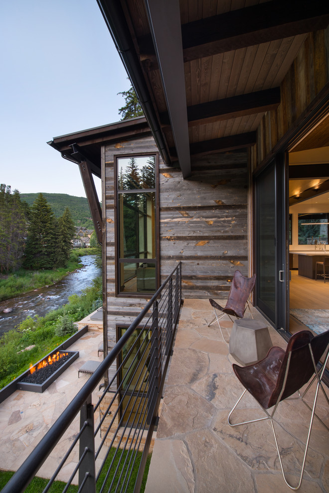 Inspiration for a mid-sized country balcony in Denver with a roof extension and cable railing.
