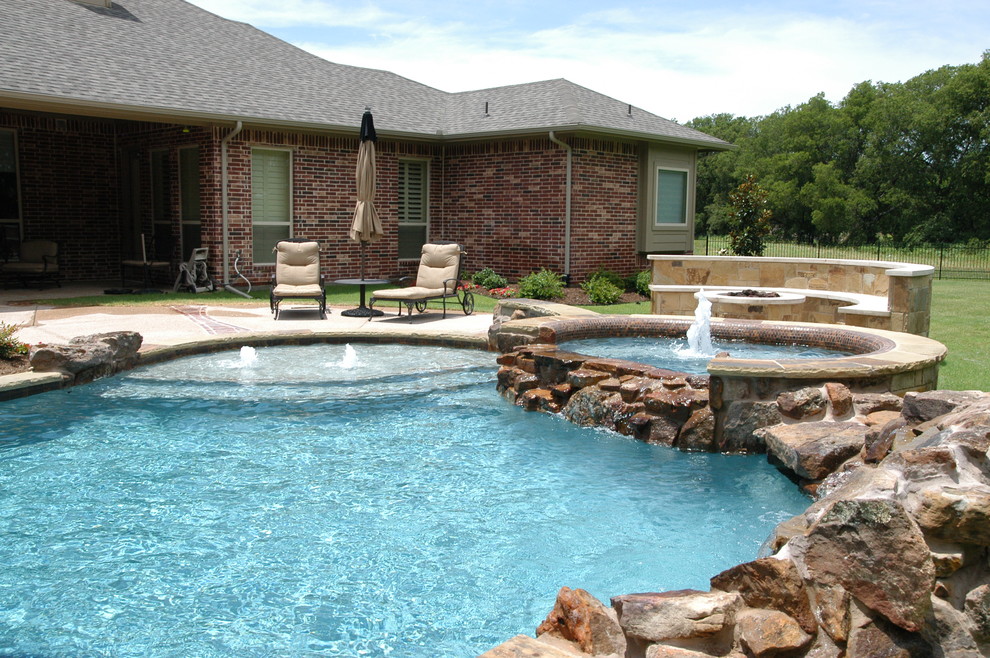 Design ideas for a large mediterranean backyard custom-shaped natural pool in Dallas with a hot tub and concrete pavers.
