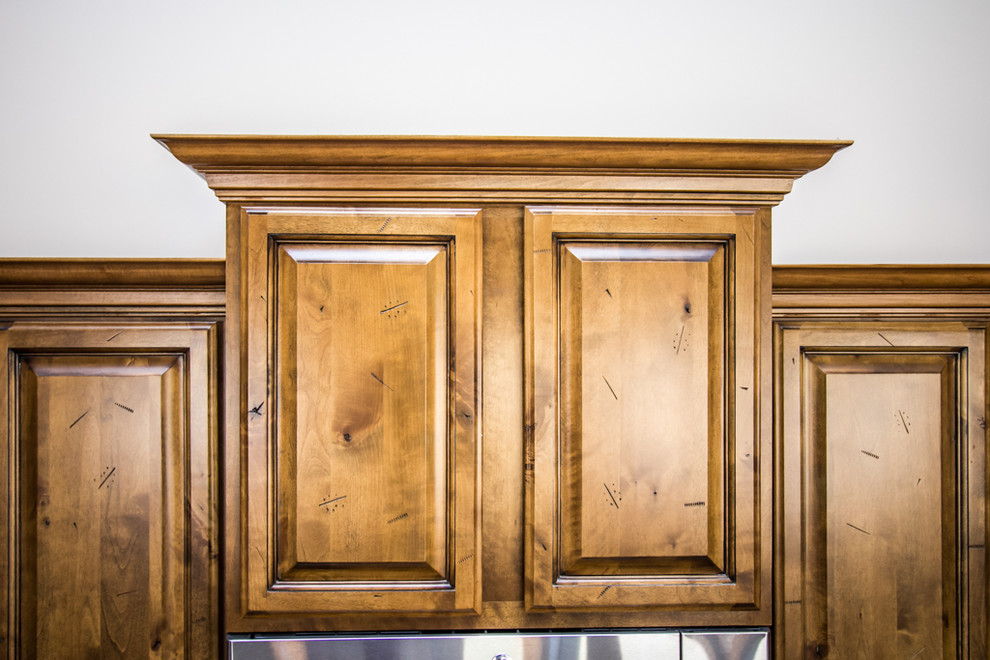 Large mountain style u-shaped slate floor eat-in kitchen photo in Phoenix with an undermount sink, raised-panel cabinets, brown cabinets, granite countertops, beige backsplash, stone tile backsplash, stainless steel appliances and two islands
