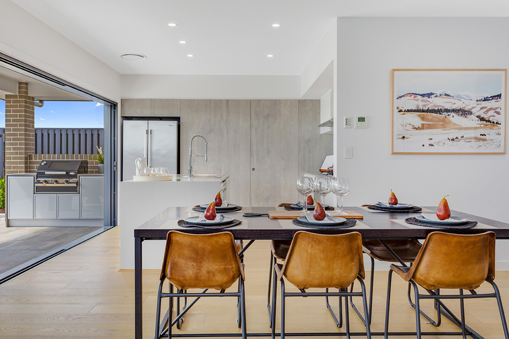 Contemporary kitchen/dining combo in Brisbane with white walls, light hardwood floors and beige floor.