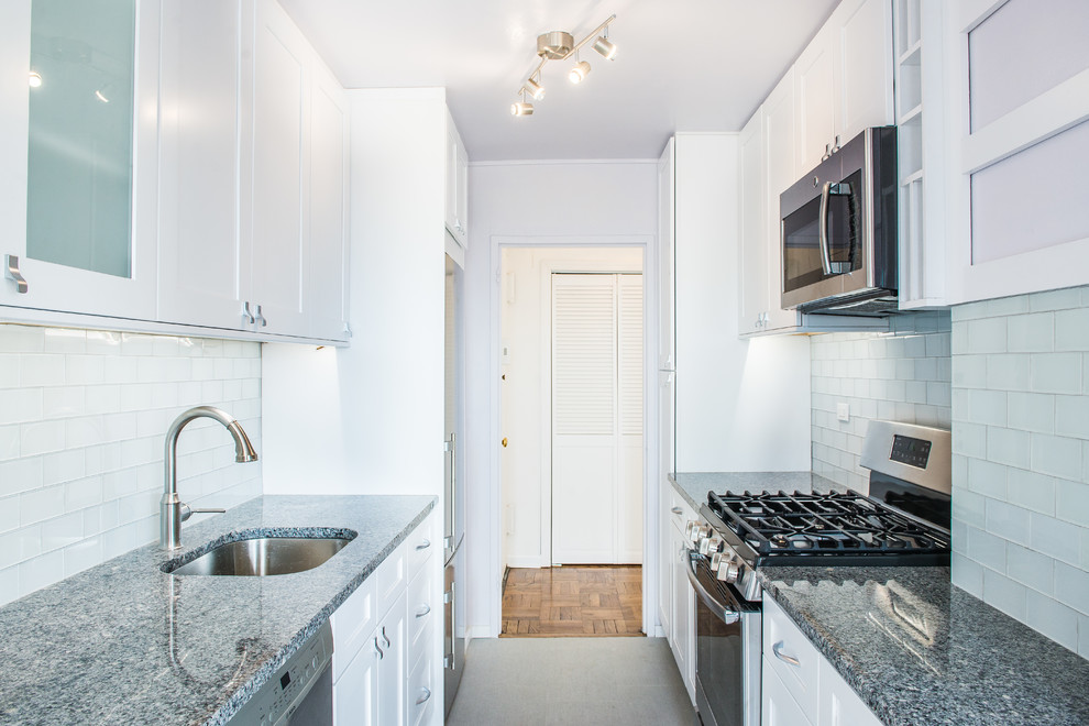 This is an example of a small transitional kitchen in New York with an undermount sink, shaker cabinets, white cabinets, quartz benchtops and stainless steel appliances.