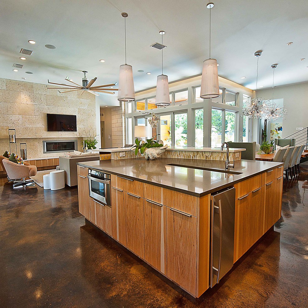 This is an example of a contemporary open plan kitchen in Austin with brown floor.