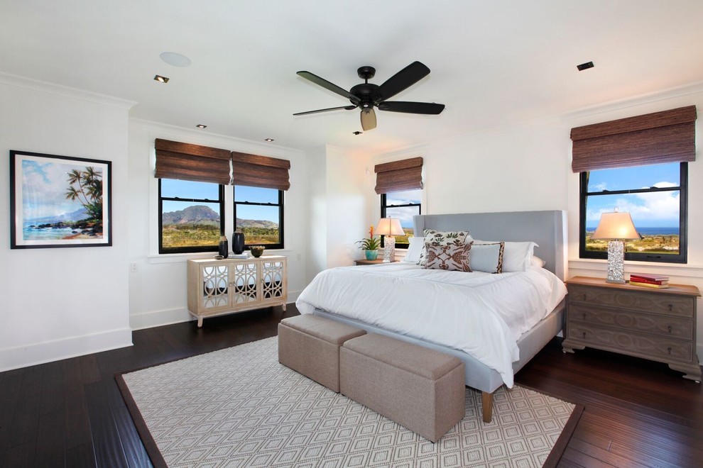 Large master bedroom in Hawaii with white walls, bamboo floors, black floor and no fireplace.