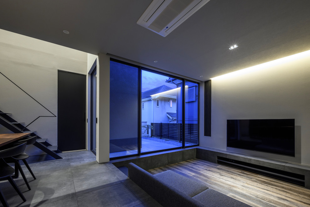 На фото: открытая гостиная комната среднего размера в современном стиле с музыкальной комнатой, серыми стенами, полом из керамической плитки, телевизором на стене, серым полом, потолком с обоями и обоями на стенах без камина