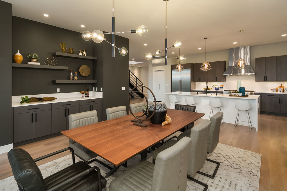 Photo of a large contemporary kitchen/dining combo in Seattle with black walls and light hardwood floors.