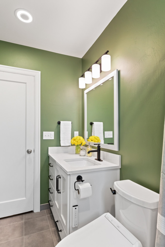 Foto på ett litet vit badrum, med vita skåp, ett badkar i en alkov, en dusch/badkar-kombination, en bidé, vit kakel, keramikplattor, gröna väggar, skiffergolv, ett undermonterad handfat, bänkskiva i kvarts, grått golv och dusch med duschdraperi