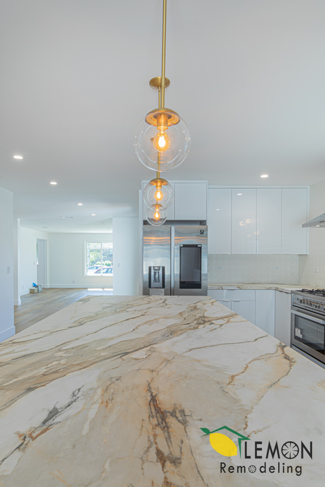 Inspiration for a modern l-shaped light wood floor kitchen remodel in San Francisco with an undermount sink, white cabinets, tile countertops, white backsplash, ceramic backsplash, stainless steel appliances and an island