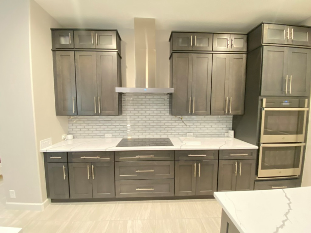 Large transitional porcelain tile and beige floor eat-in kitchen photo in Tampa with a single-bowl sink, shaker cabinets, dark wood cabinets, quartzite countertops, gray backsplash, subway tile backsplash, stainless steel appliances, an island and white countertops