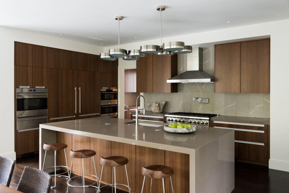 Foto på ett stort 60 tals grå kök, med en dubbel diskho, skåp i shakerstil, skåp i mellenmörkt trä, bänkskiva i betong, grått stänkskydd, rostfria vitvaror, mörkt trägolv, en köksö och brunt golv