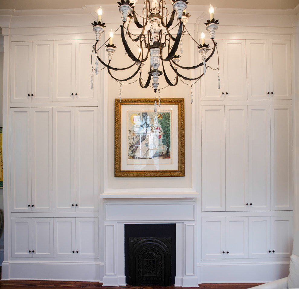 Photo of a large transitional study room in New Orleans with beige walls, medium hardwood floors, a standard fireplace, a metal fireplace surround, a freestanding desk and brown floor.