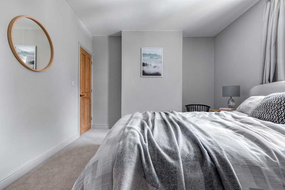 Mid-sized scandinavian guest bedroom in Hertfordshire with grey walls and carpet.
