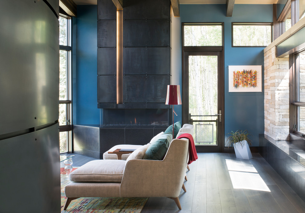 Photo of a contemporary living room in Denver with blue walls and a metal fireplace surround.