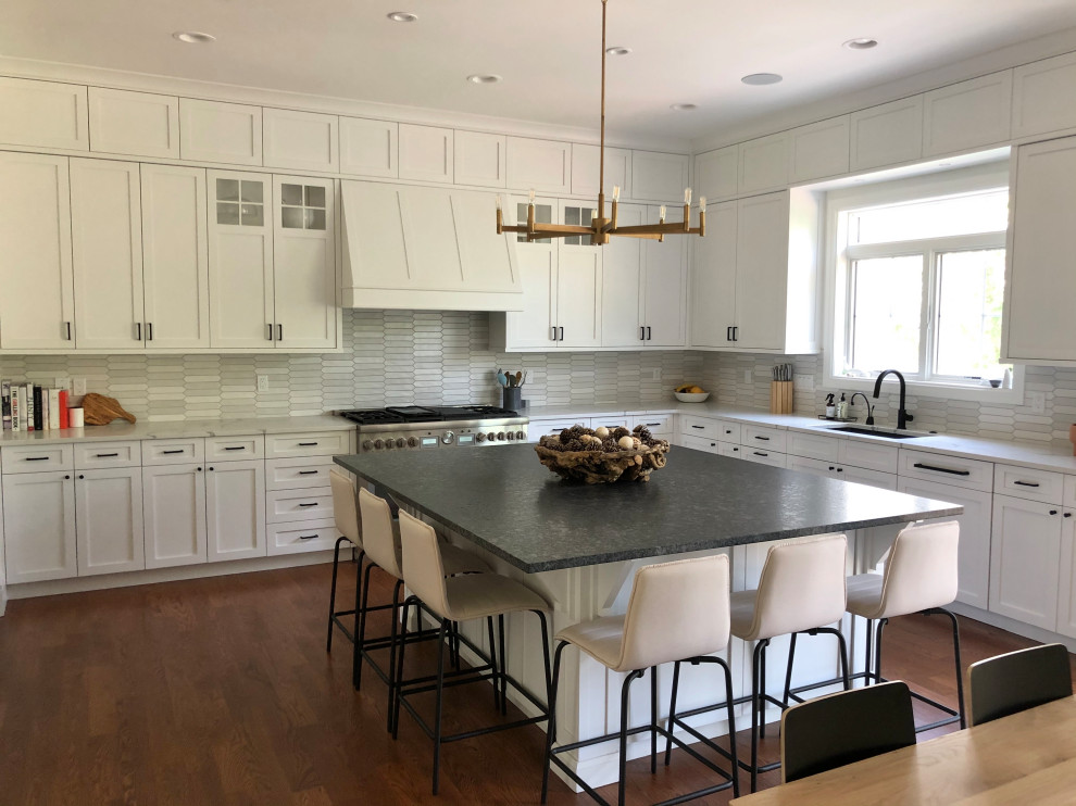 Inspiration for a country kitchen in Detroit with a drop-in sink, shaker cabinets, white cabinets, quartz benchtops, grey splashback, porcelain splashback, panelled appliances, medium hardwood floors, brown floor and white benchtop.