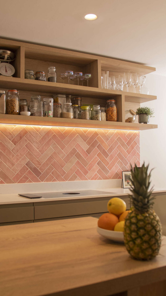 Design ideas for a mid-sized contemporary l-shaped eat-in kitchen in Sussex with flat-panel cabinets, light wood cabinets, quartzite benchtops, pink splashback, terra-cotta splashback, with island and white benchtop.