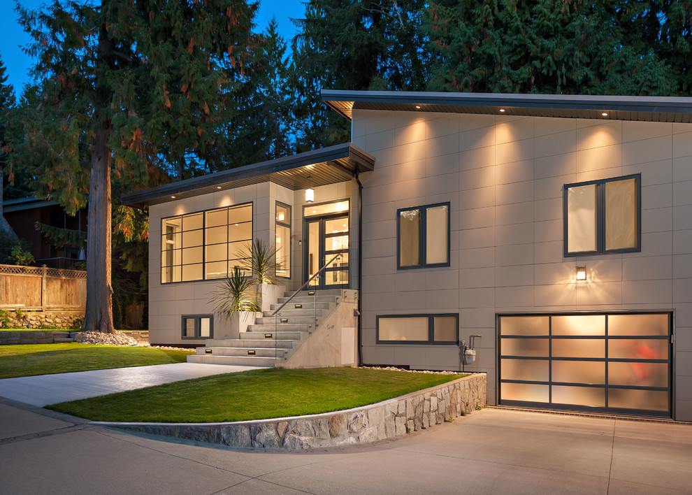 This is an example of a large modern two-storey beige exterior in Vancouver with stone veneer and a shed roof.