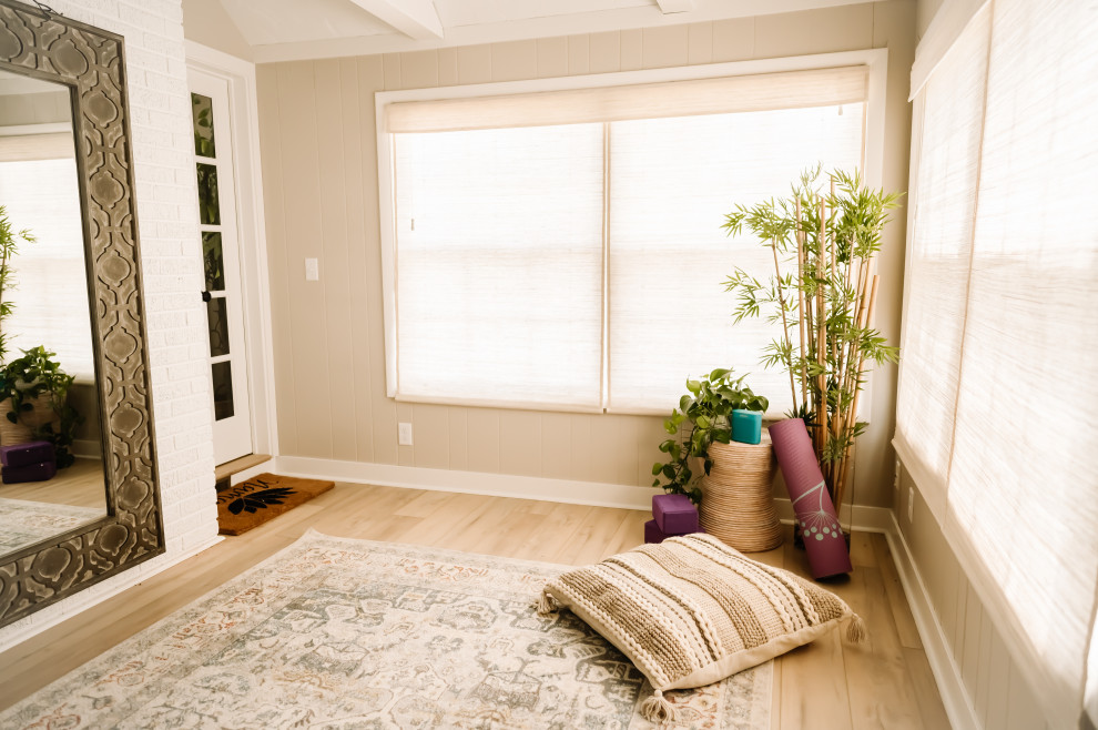 Example of a trendy medium tone wood floor and brown floor home yoga studio design in Cedar Rapids with beige walls