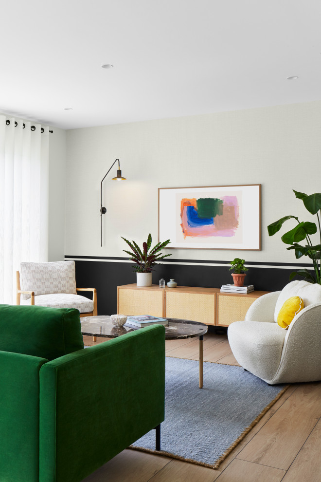 Idée de décoration pour un salon design ouvert avec un mur beige, parquet clair et un téléviseur dissimulé.