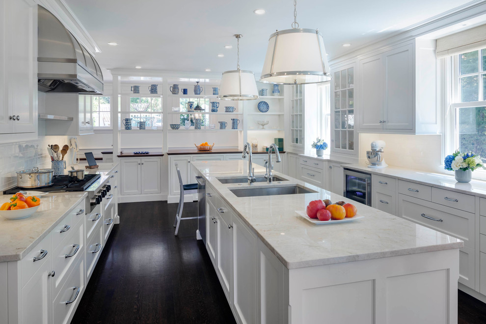 Inspiration for a mid-sized traditional u-shaped open plan kitchen in Boston with an undermount sink, shaker cabinets, white cabinets, marble benchtops, white splashback, subway tile splashback, stainless steel appliances, dark hardwood floors, with island and brown floor.