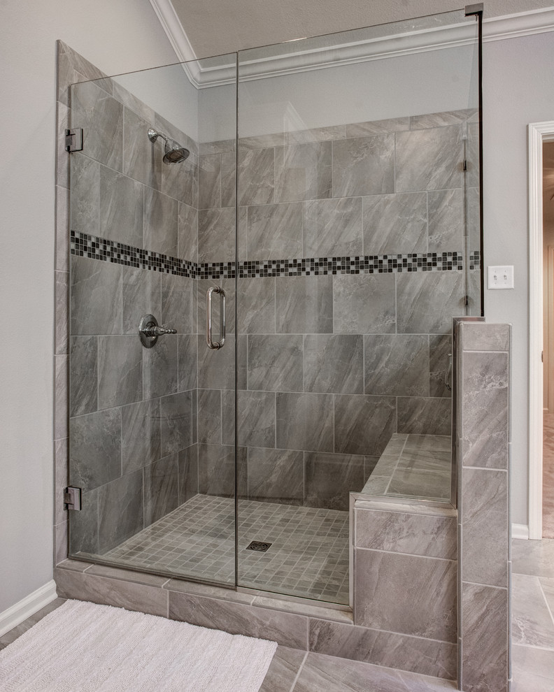 Photo of a mid-sized transitional master bathroom in Little Rock with shaker cabinets, white cabinets, a drop-in tub, an open shower, a one-piece toilet, gray tile, white tile, stone tile, grey walls, ceramic floors, a drop-in sink and solid surface benchtops.