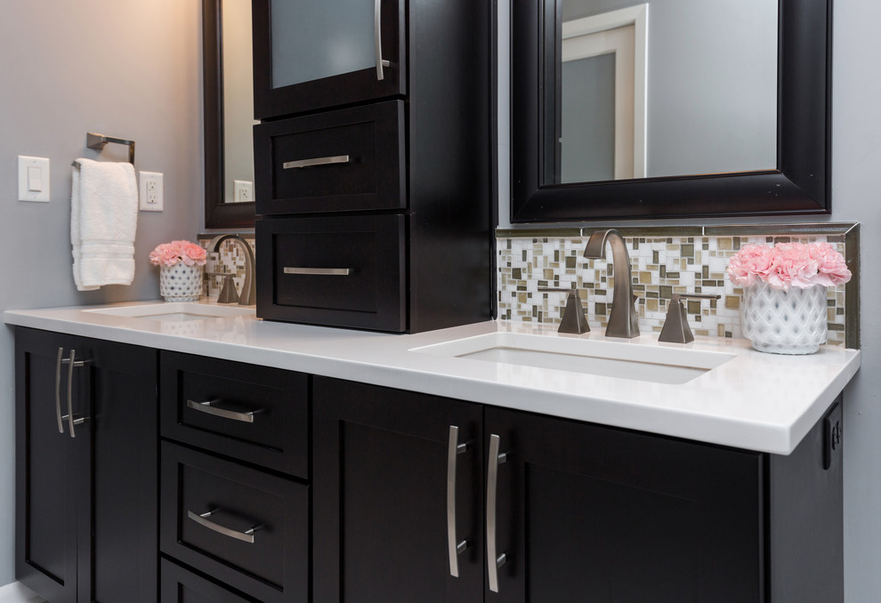 Mid-sized transitional master gray tile and mosaic tile marble floor walk-in shower photo with an undermount sink, recessed-panel cabinets, dark wood cabinets, quartzite countertops, a one-piece toilet and gray walls