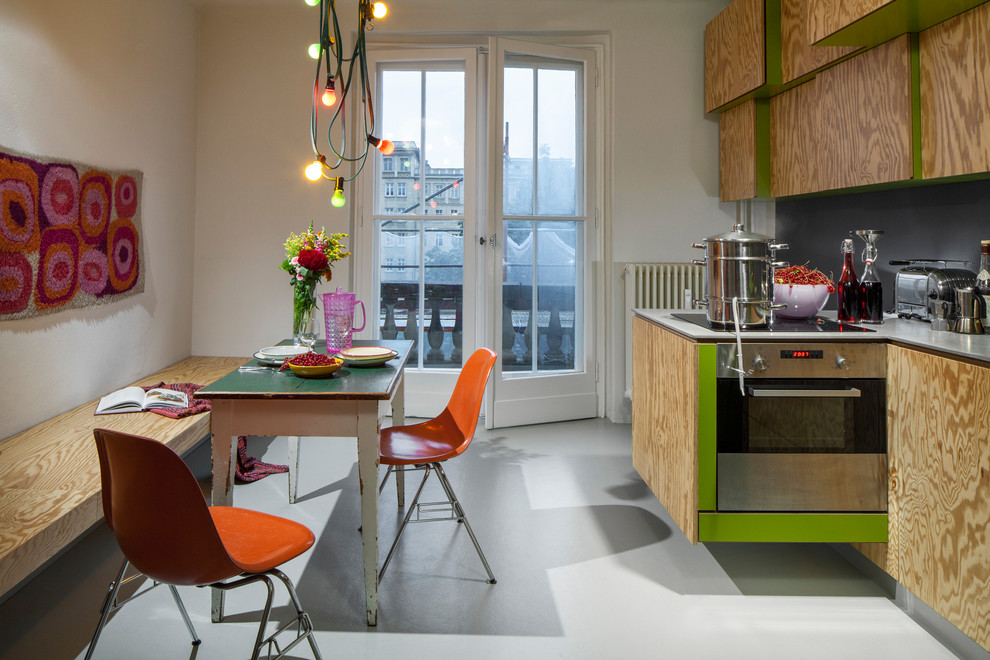 Photo of an eclectic single-wall eat-in kitchen in Berlin with flat-panel cabinets, medium wood cabinets, no island, grey floor and grey benchtop.