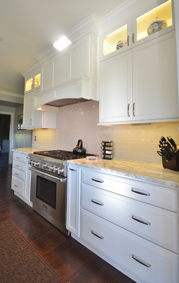 Example of a huge transitional l-shaped dark wood floor and brown floor eat-in kitchen design in Philadelphia with an undermount sink, raised-panel cabinets, white cabinets, granite countertops, white backsplash, subway tile backsplash, paneled appliances and an island