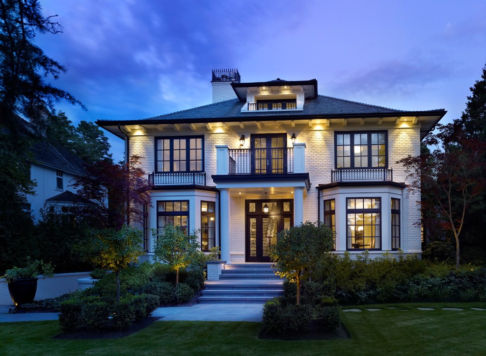 Photo of a large traditional two-storey brick white house exterior in Vancouver with a hip roof and a shingle roof.
