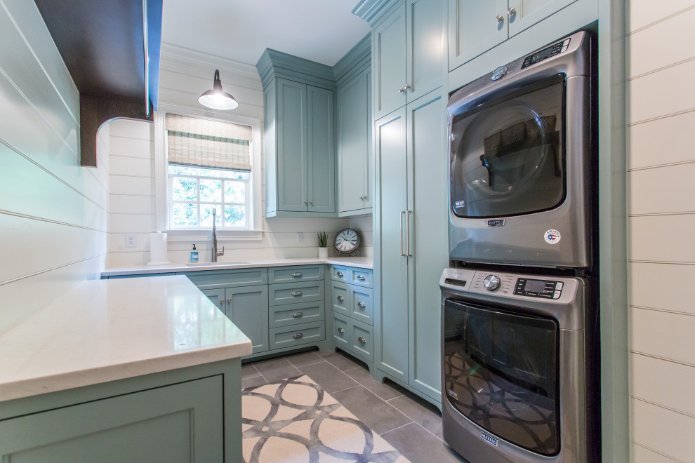 Design ideas for a country laundry room in Atlanta with shaker cabinets, turquoise cabinets, white walls, ceramic floors, a stacked washer and dryer, grey floor and white benchtop.
