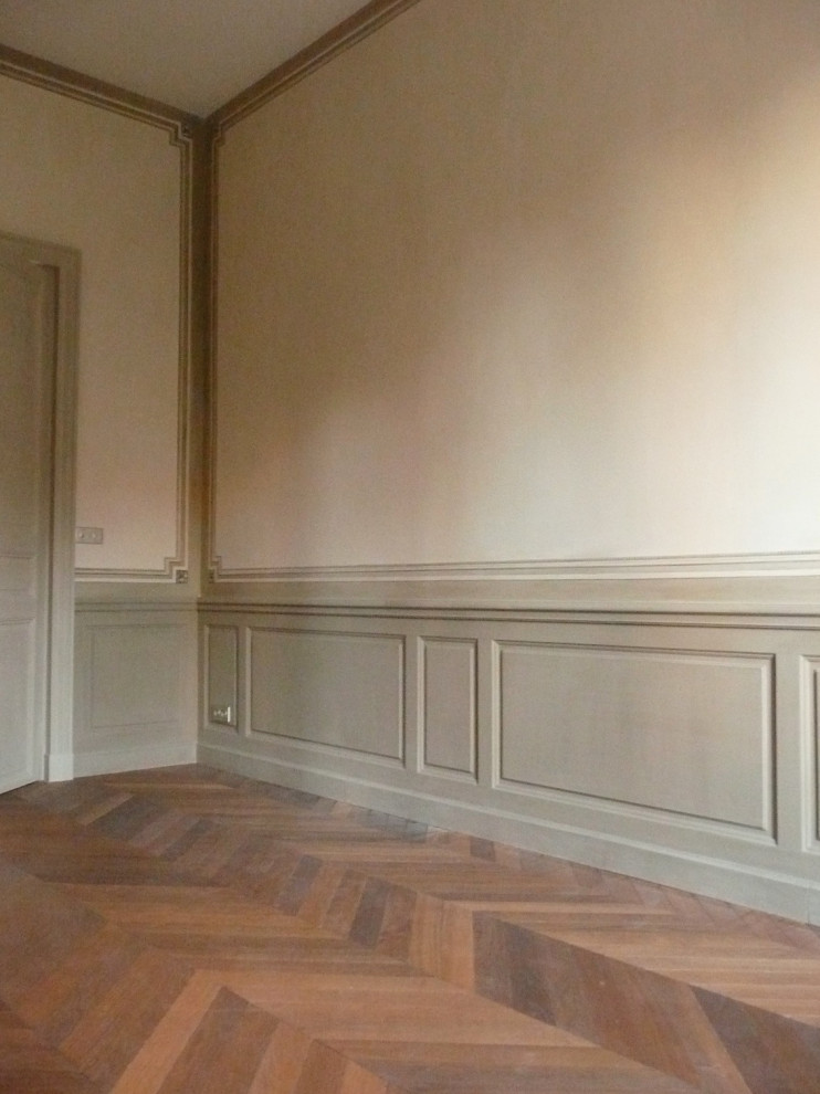 Photo of a transitional master bedroom in Marseille with beige walls, medium hardwood floors and brown floor.