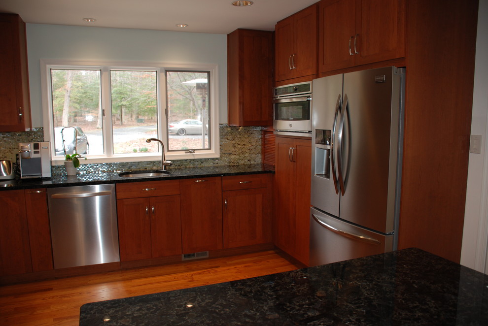 This is an example of a large transitional u-shaped eat-in kitchen in DC Metro with an undermount sink, shaker cabinets, medium wood cabinets, granite benchtops, multi-coloured splashback, mosaic tile splashback, stainless steel appliances, medium hardwood floors and with island.