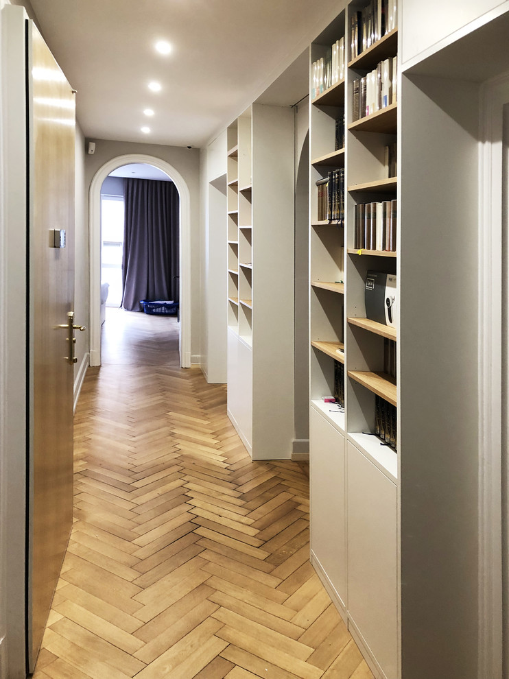 Idées déco pour un grand couloir classique avec parquet clair et un mur beige.
