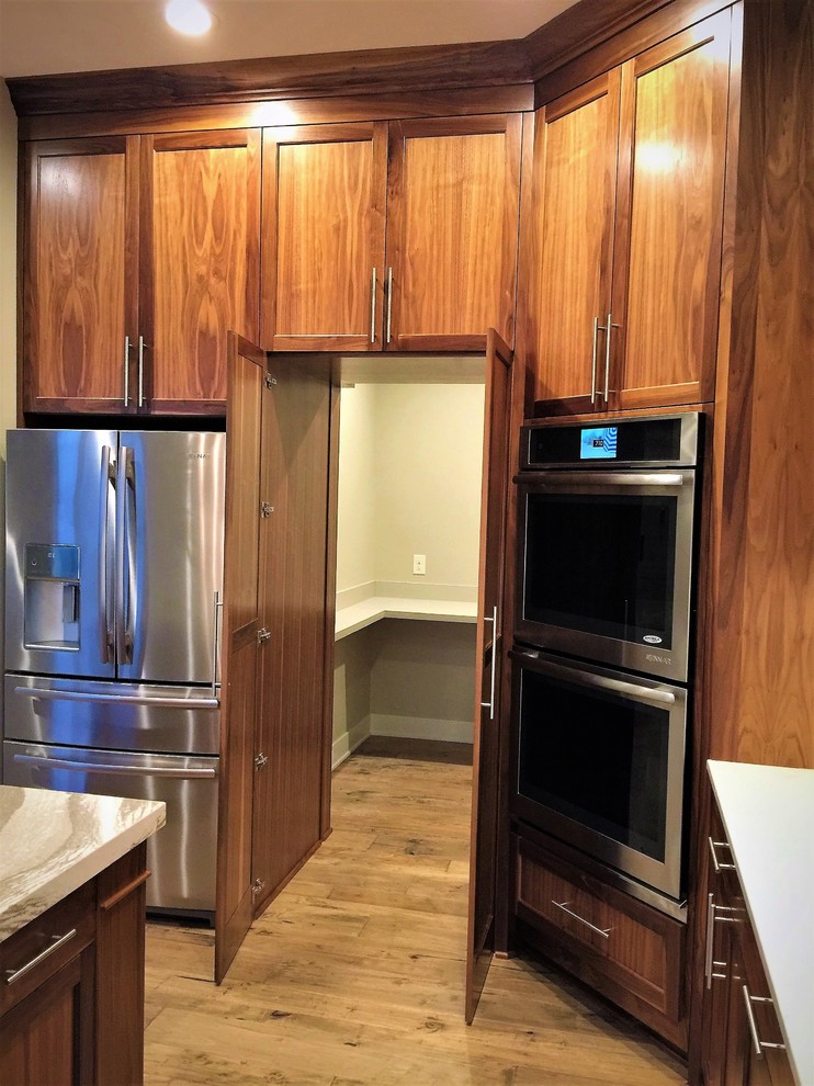Eat-in kitchen - large transitional u-shaped light wood floor and brown floor eat-in kitchen idea in Omaha with an undermount sink, shaker cabinets, medium tone wood cabinets, quartz countertops, white backsplash, subway tile backsplash, stainless steel appliances, an island and white countertops